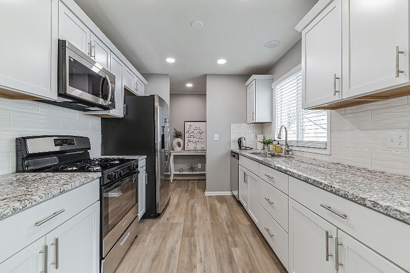 Kitchen with granite countertops and stainless-steel appliances, stocked with everything you need to feel at home.