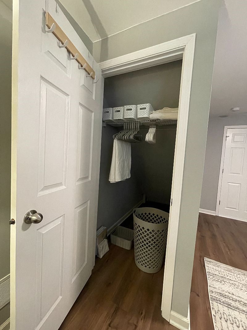 Large clean and fresh closet with organizer system and lots of hangers and baskets for all of your storage needs.