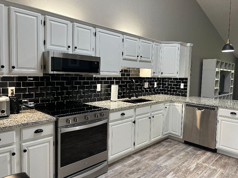 Kitchen with subway tile backsplash and stainless steel appliances