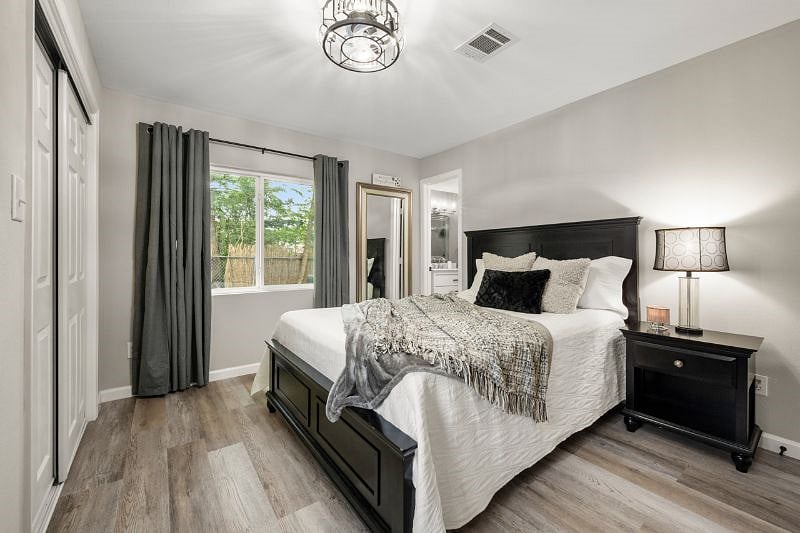 The primary bedroom features an ensuite. 2 large windows, with blackout curtains. Closet with shelves and hangers. Plus a dresser for extra storage.