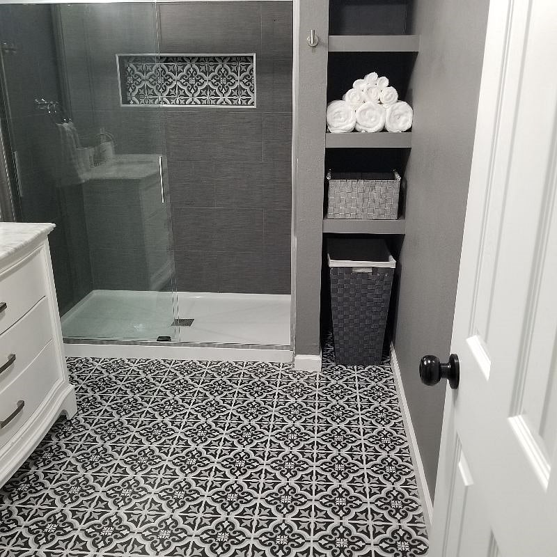 The primary bathroom features an ensuite with a large walk-in shower that has a shampoo nook for all of your favorite bath products. Plus, in bathroom shelving for your towels and laundry basket.