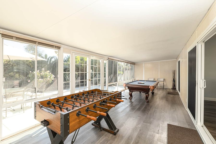 A spacious game room featuring both a pool table and foosball-perfect for family fun and friendly competition.