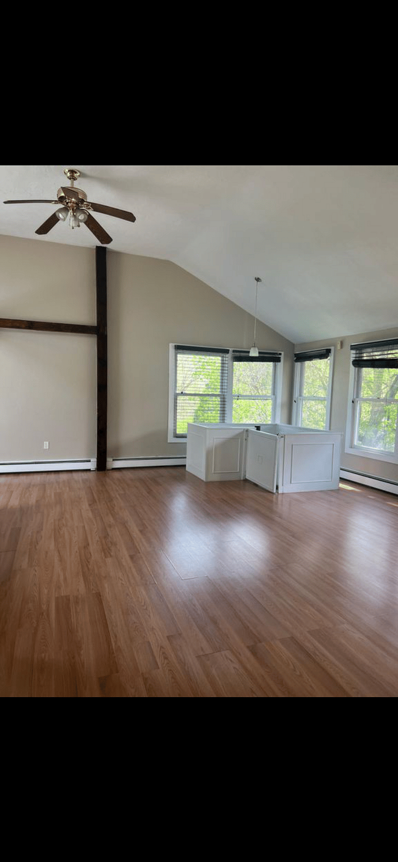 Furnishings to include dining table in the far end with a large sectional couch.