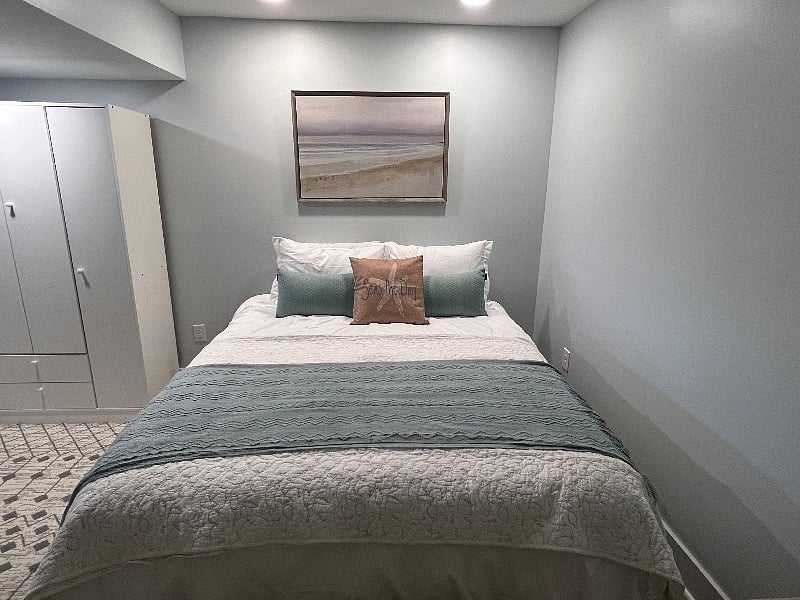 A night stand has been added to the left of the bed and storage to the right.