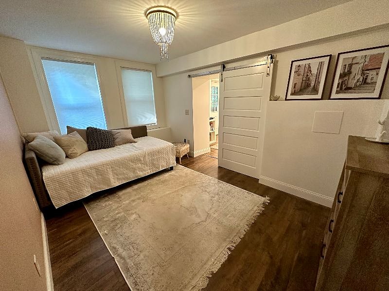 Bedroom with twin daybed. Nightstand and lamp and matching dresser. We are installing a rack to hang clothing.