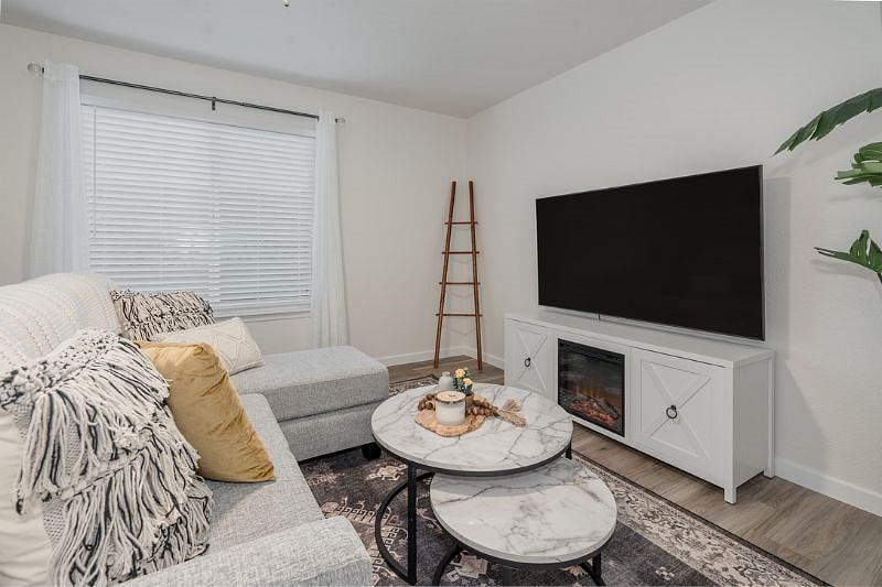 Welcome to our spacious living area, bathed in natural light. Electric Fireplace and Smart TV