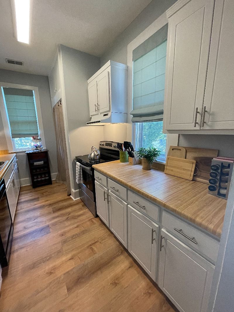 The kitchen features a newer stainless full size fridge and smooth top oven, dishwasher, and all the comforts of home for meal prep and dining, including a coffee pot, toaster, cookware, serveware, spices.