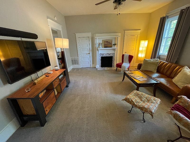 This large den area features tall ceilings, a large SMART TV with sound bar, sofa (can also be folded out to a full size bed), side chairs, plenty of room to relax