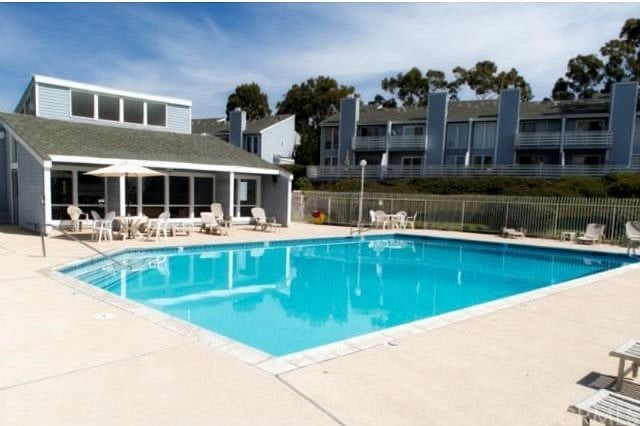 Community pool and loungers with tables and umbrellas