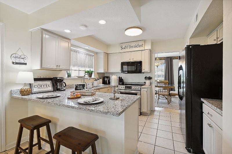 Full size kitchen with appliances dishwasher, stove and refrigerator with door ice maker.