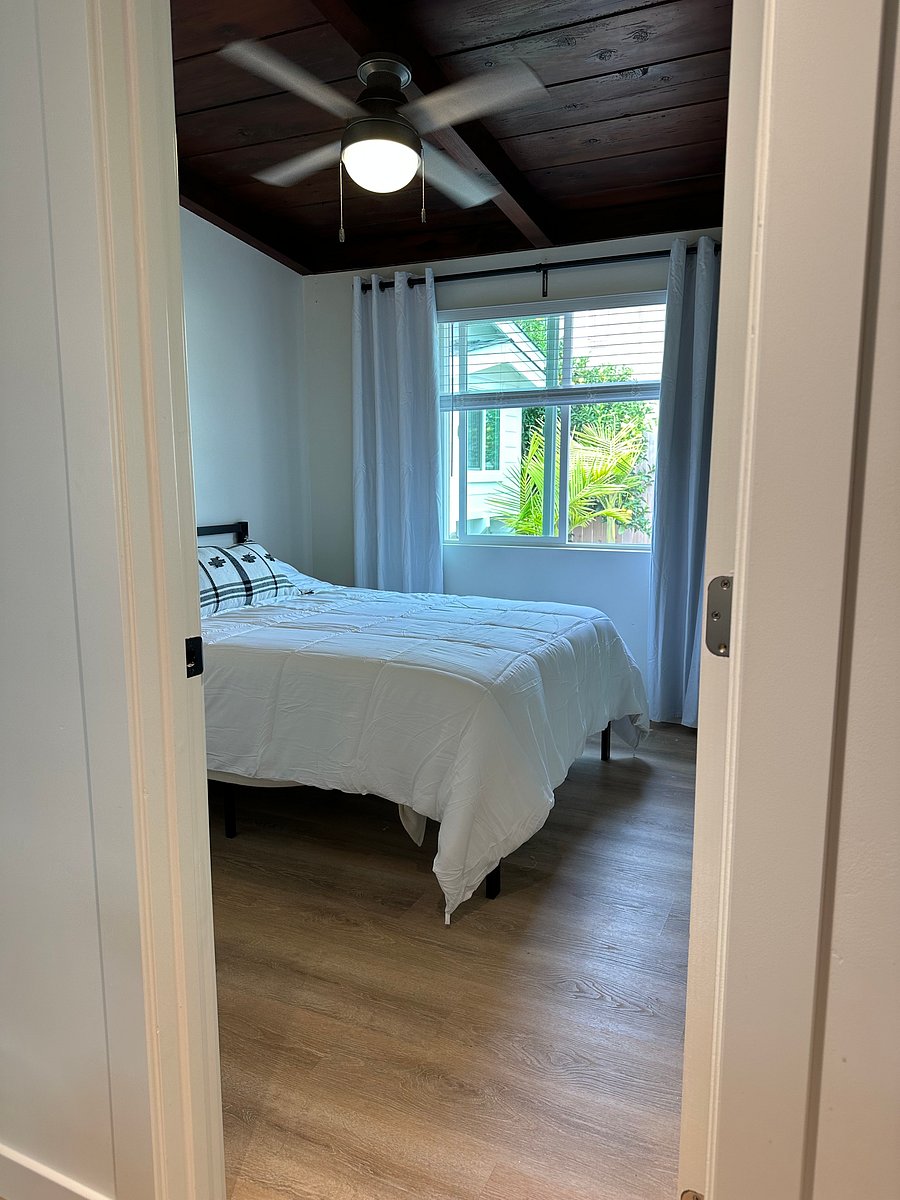 Full size bed has mirrored closets, and ceiling fan with a beautiful wood ceiling.