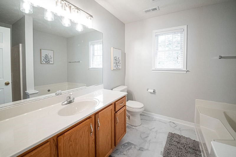 The primary ensuite boasts a large vanity, toilet, walk-in shower and soak tub.