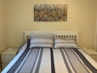 Bedroom on main floor with queen size bed and smart TV