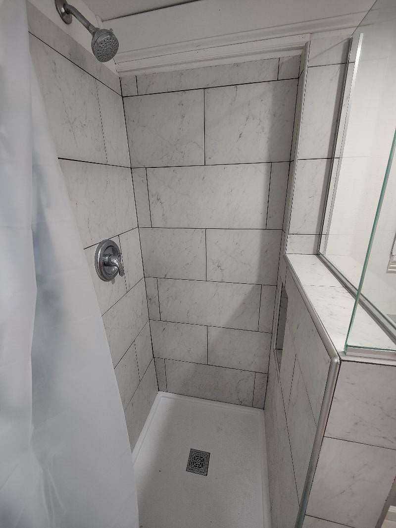Tiled shower with glass wall gives an open feeling to the bathroom and allows light to fill the space. Vent fans keep the space dry even during the hottest showers. 