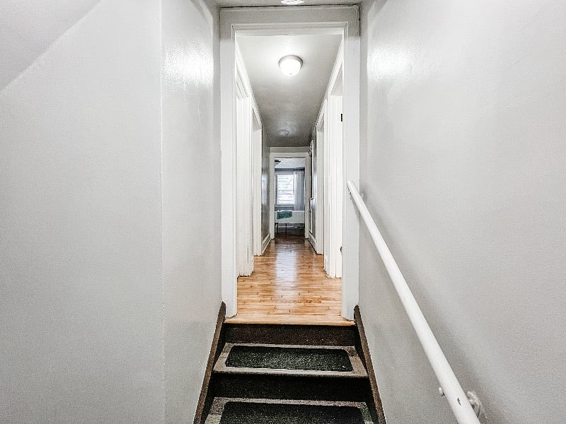 View of upstairs hallway. Full bathroom and bedroom with twin bed on the right. Left side of hallway has third bedroom with queen bed. End of hallway is fourth bedroom with queen bed and desk workspace. :)