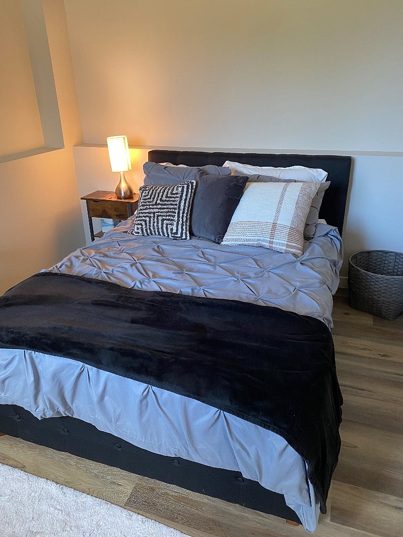 Full size bed, dresser, shelf & rack in room