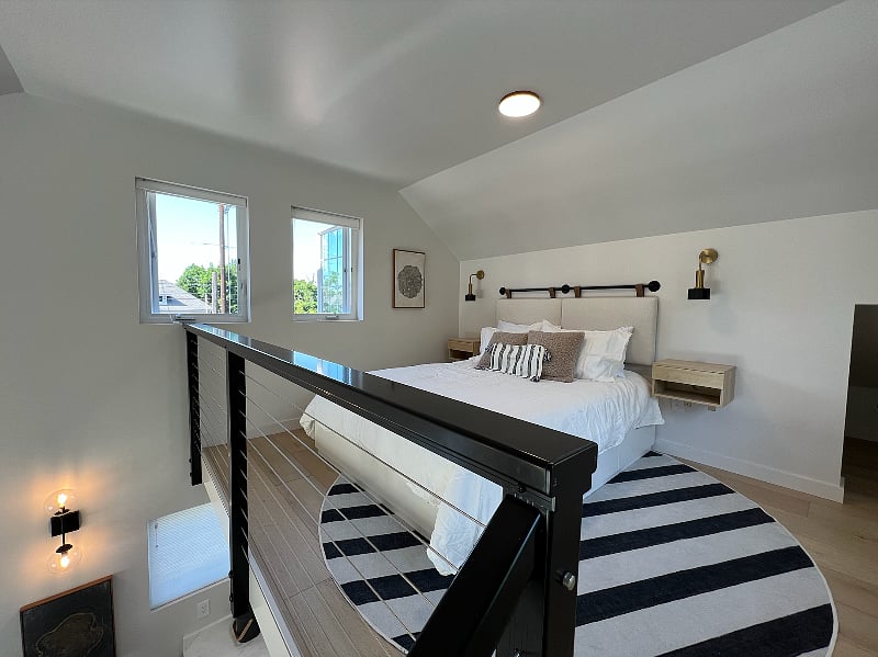 Plenty of room for a queen bed! There's also a small storage nook for suitcases / luggage, a hamper, and more. The bed itself is a platform bed with 6 deep drawers underneath for extra storage