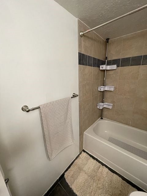 Shower organizer and bathtub, with bars and hooks for hanging towels.