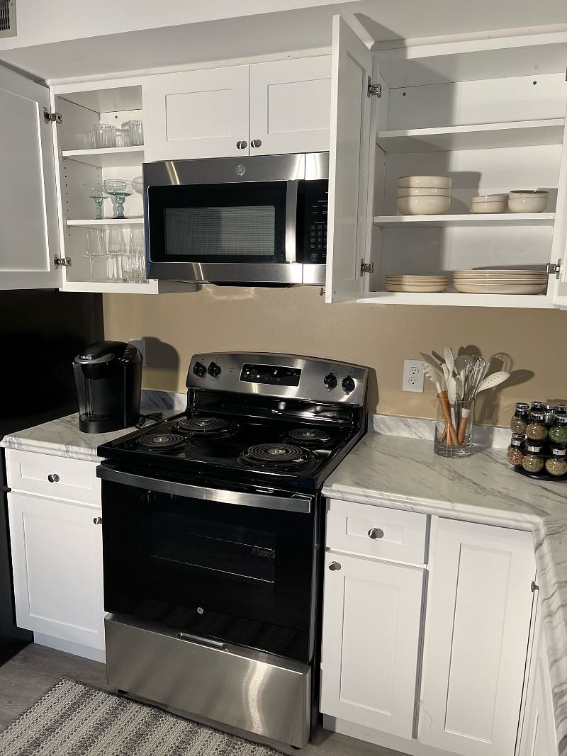 Kitchen- stocked with glassware, pots, pans, cooking utensils and tableware. Coffee machine and Keurig pods are provide. A toaster is stored in the upper right-hand cabinet. Paper towels are stored in the top cabinet above the oven and cleaning supplies are located under the sink. 