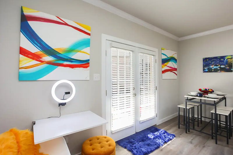 Shared workstation, with streaming ring light and phone holder. Great for teleconferencing or quick meetings. French doors to one a shared balcony.