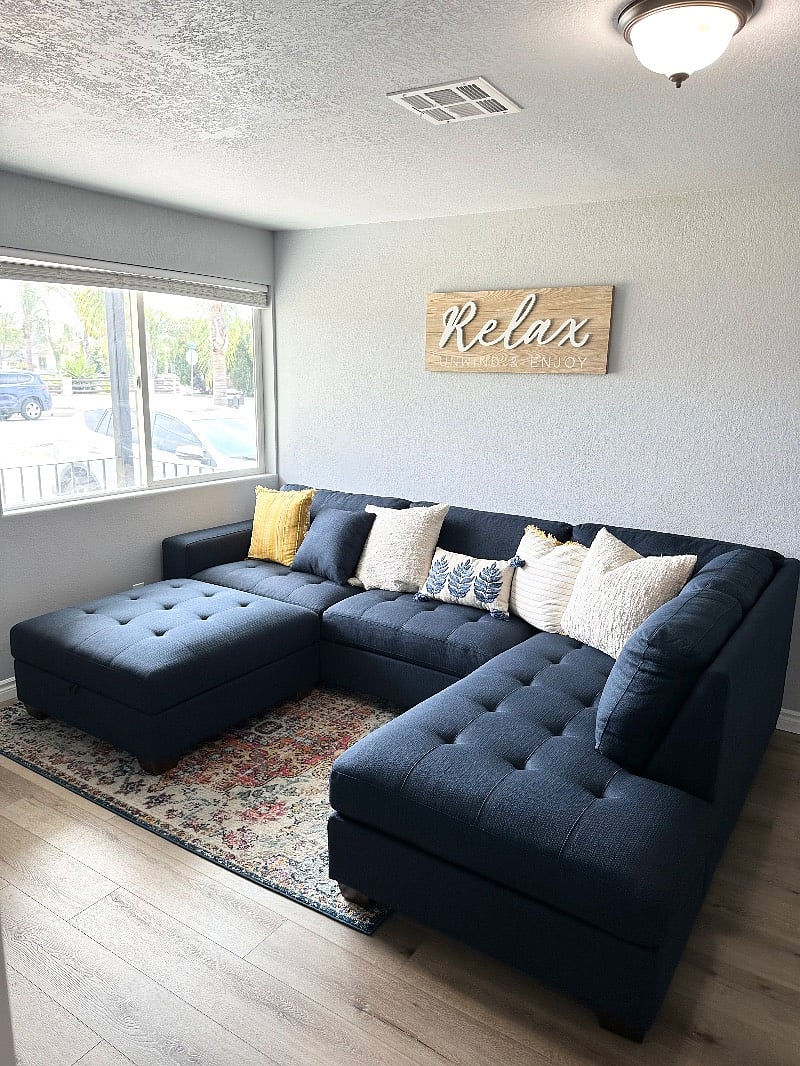 Open concept living room with street view, brand new sectional, and a 55 smart TV.