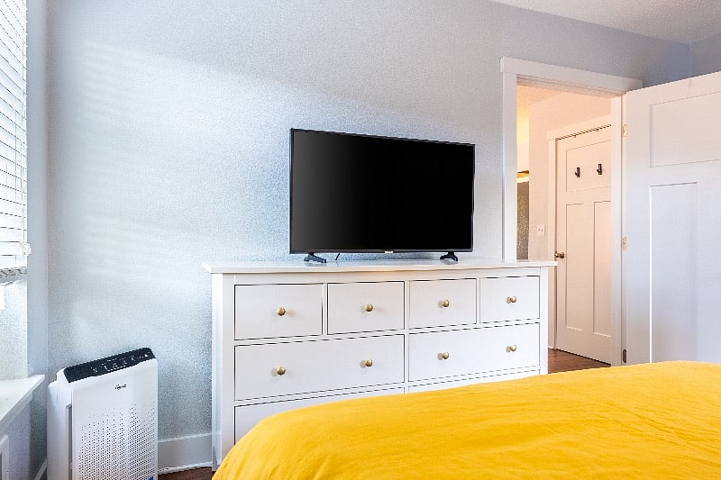 Dresser for extra storage in bedroom and Samsung smart TV.