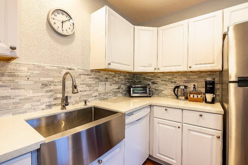 Full sized kitchen sink, refrigerator, dishwasher, and new quartz countertops.