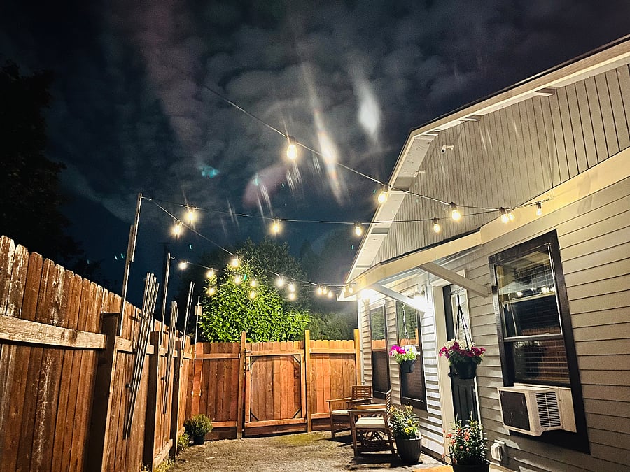 Night sky with string lights in gated private patio.