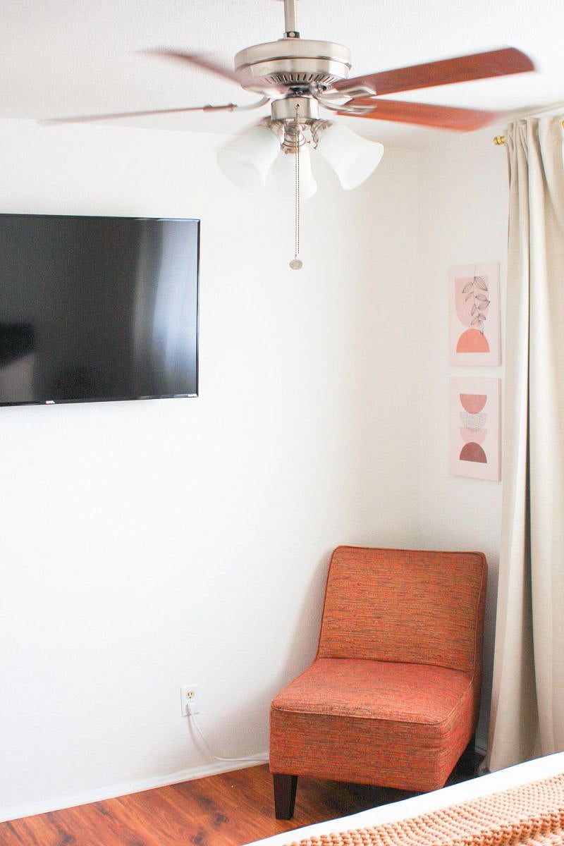 50 inch smart Tv in primary bedroom with seating/ reading area.