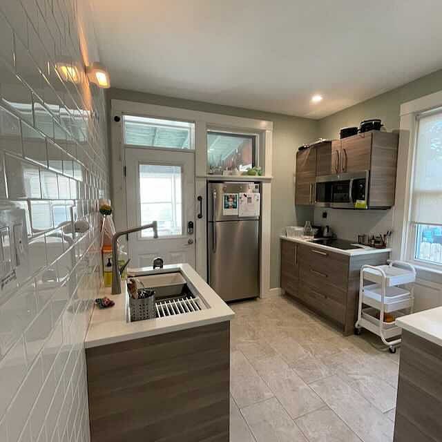 Reverse view of kitchen with large Kohler sink and other appliances.