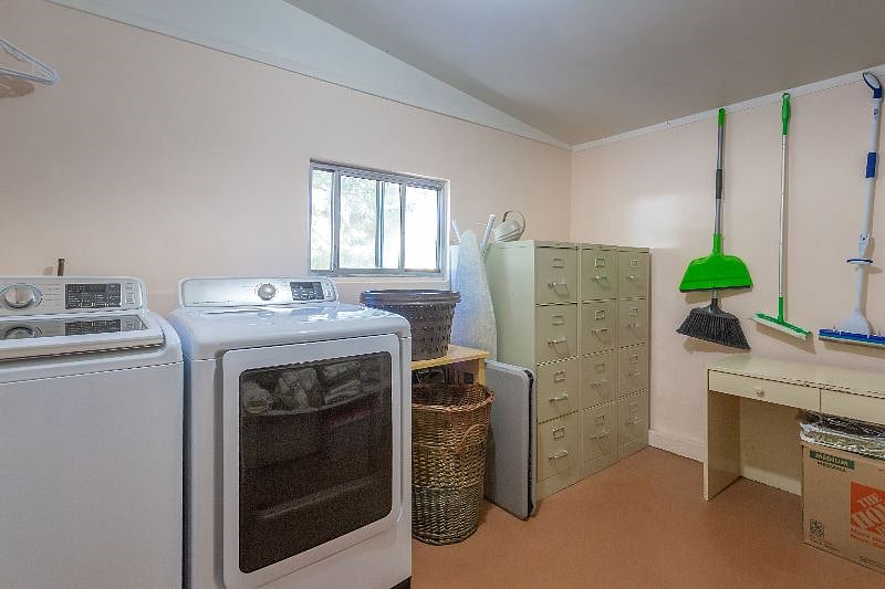 The laundry room has a new washer and dryer, brooms, mops, cleaning supplies, laundry soap. There's an iron and ironing board as well.