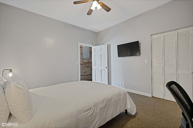 1st bedroom showing the queen size bed, a TV, and closet