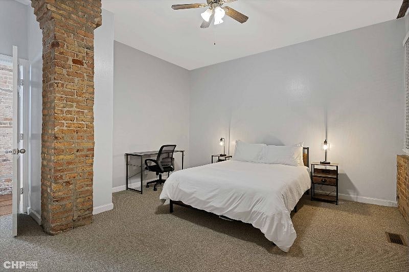 2nd bedroom showing the desk, a queen size bed, and bedside tables with lamps
