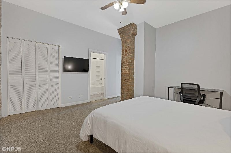 2nd bedroom showing the queen size bed, a TV, and closet