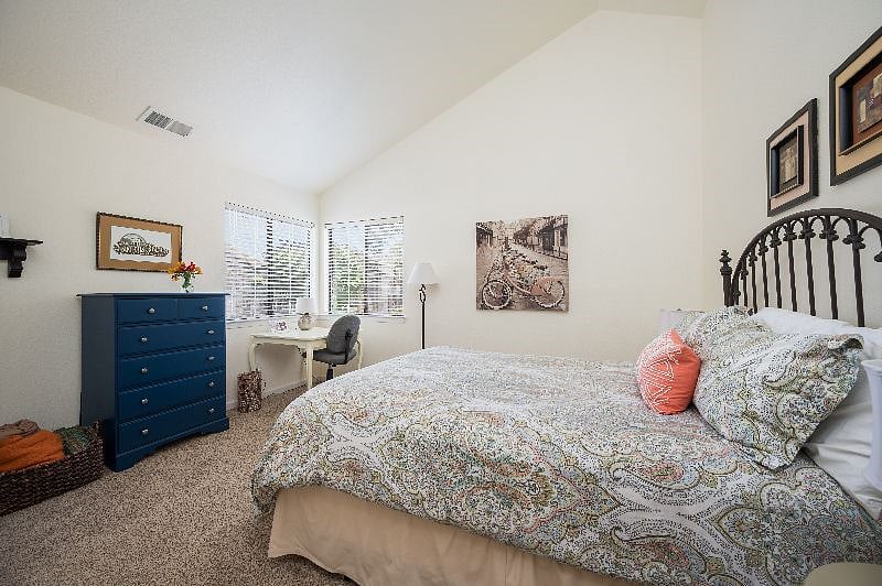 Bedroom #2: Queen sized bed, high ceilings, natural light.
Furnishings include tall dresser and table-style desk.