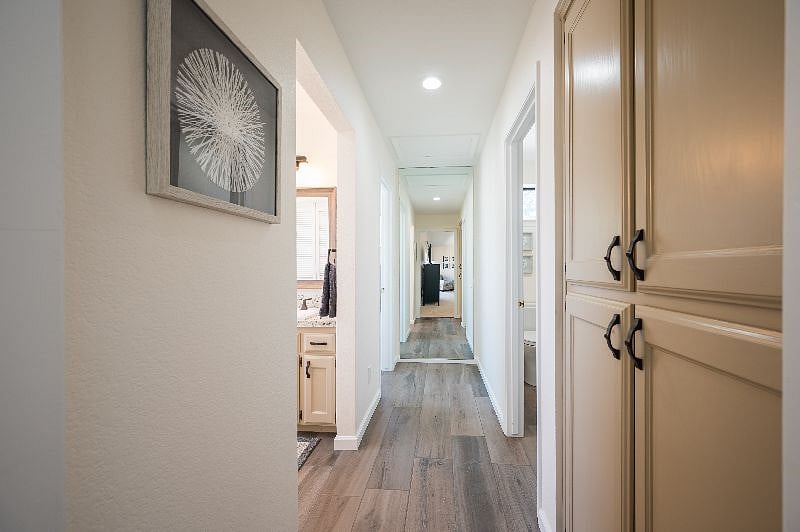 Main bedroom hallway to bathroom areas. All tile. Large wall mirror at the end of the hallway.