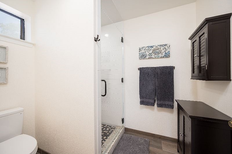 Walk in shower with river rock floor, toilet. New tile floor.