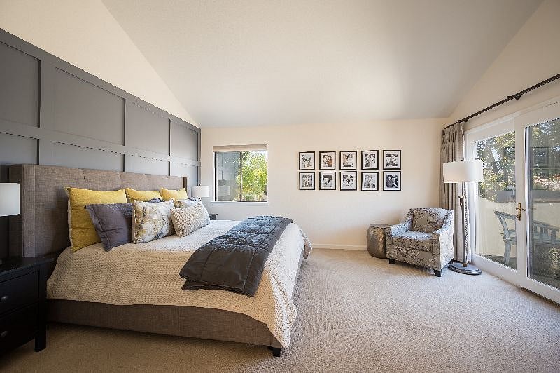 Spacious main bedroom has king bed, chair and lamp for reading, tall dresser, bedside tables with lamps. Opens to a small deck with mountain views.