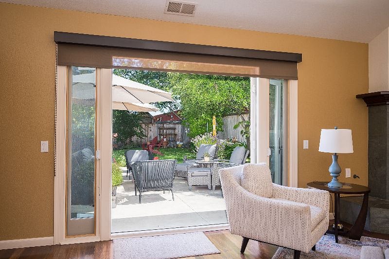 Living room opens on to upper patio of the backyard. Wide glass doors bring the outside in.