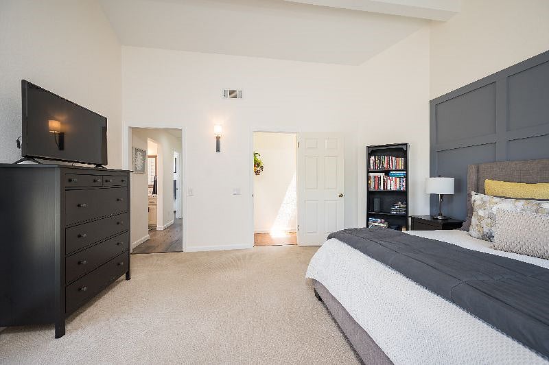 Main bedroom --this view shows tall dresser, bathroom access, exit to stairs.