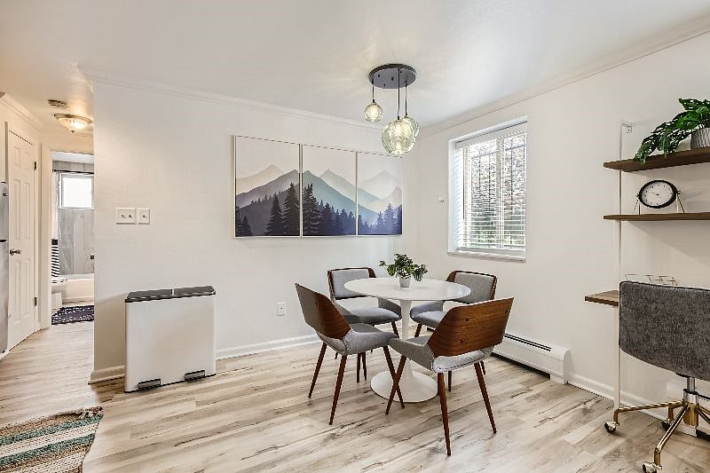 The open concept kitchen and dining area features a stylish dining table with seating for four. Down the hallway, you will find the bedroom and bathroom.