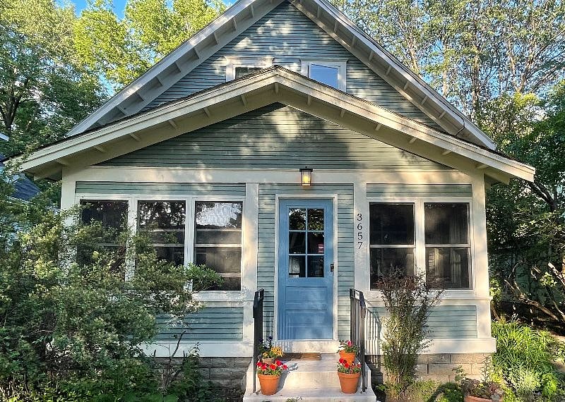 Front of house: two steps up to front stoop, handrails both sides