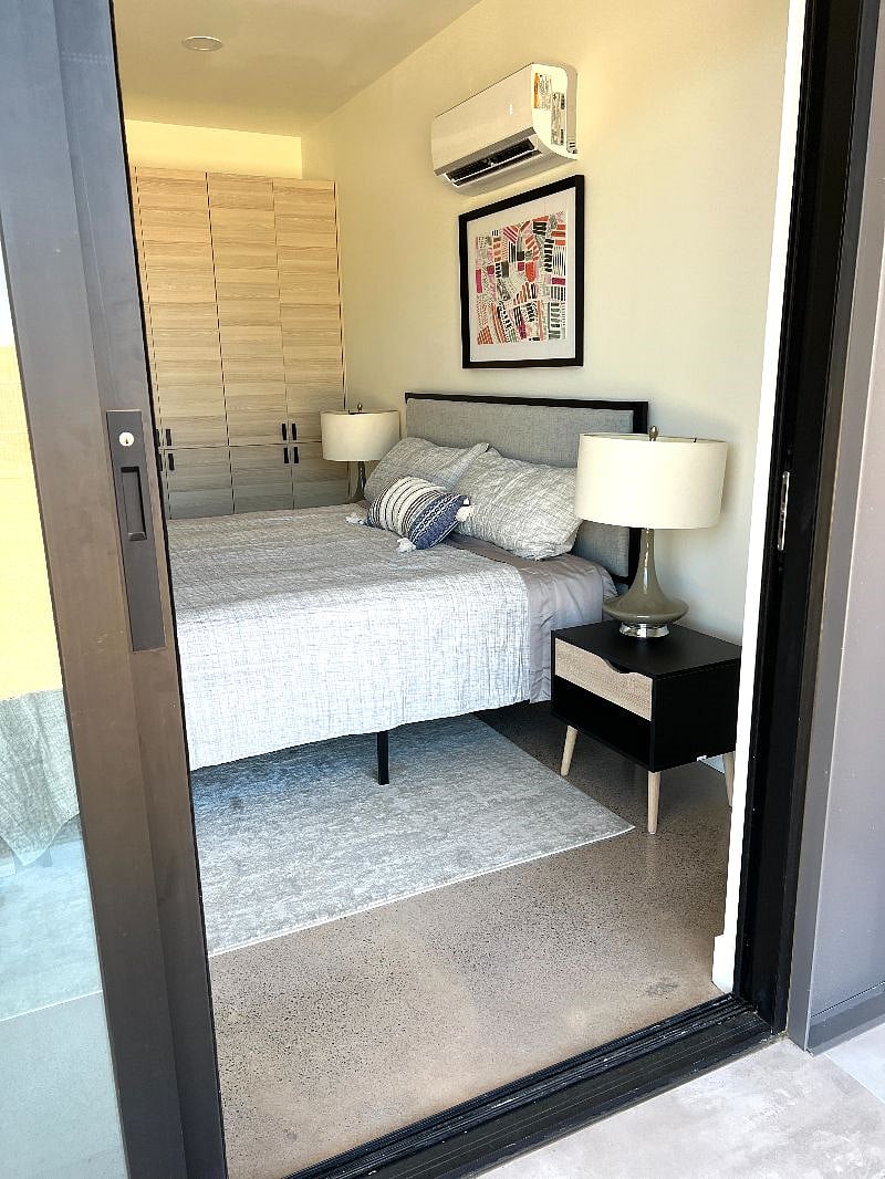 View of bedroom from front patio with sliding glass doors open 