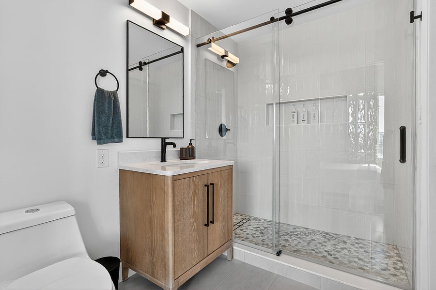 Brand new master bathroom with sliding glass panel to access stand up shower, custom niche, and linear drain.