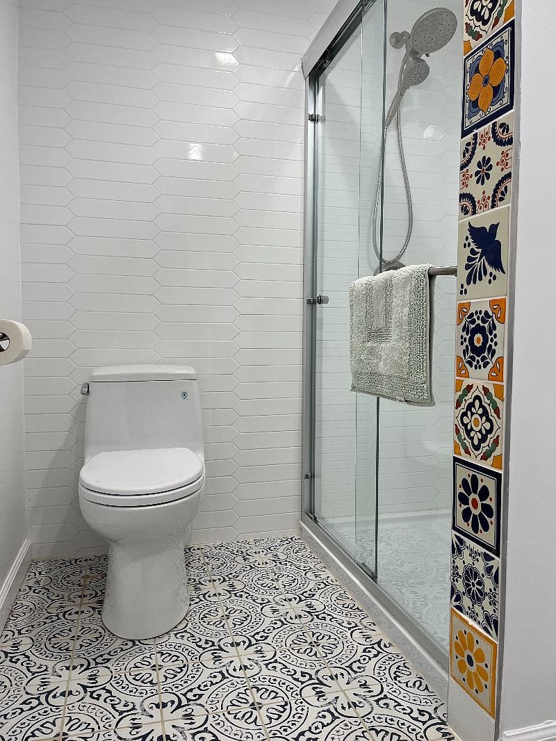 Bathroom with Talavera tile work and robust, removable shower head.