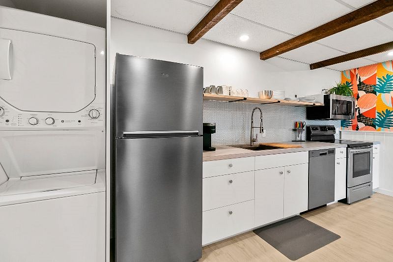 In-unit washer and dryer alongside fully stocked kitchen