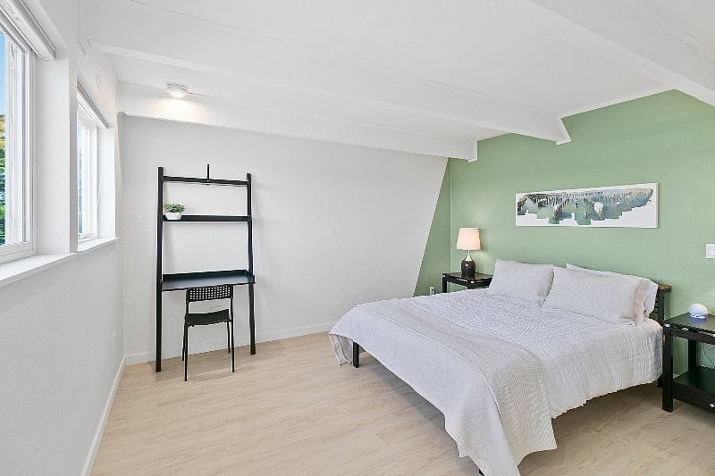 Peaceful bedroom with workstation. An Unlimited membership to Vibe Coworks is included at no additional charge ($340/mo value) if you are traveling with a partner who needs additional remote work amenities