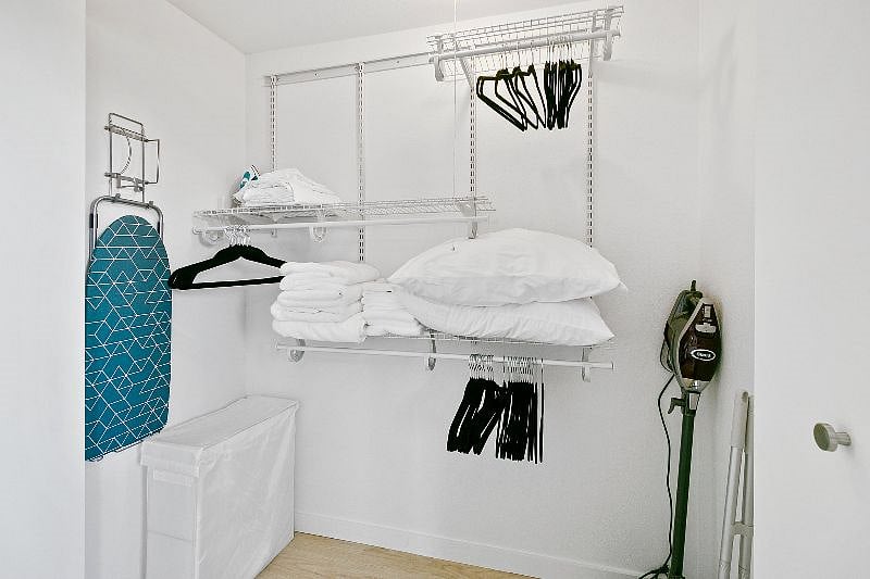 Ample closet space with fresh linens, extra pillows, ironing board and cleaning supplies