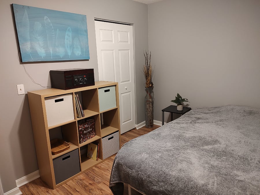 Second bedroom with queen sized bed, work station, and storage.