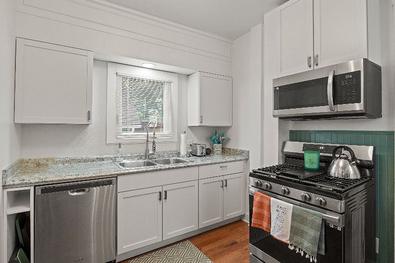 Kitchen view featuring brand new Samsung stainless steel microwave and oven